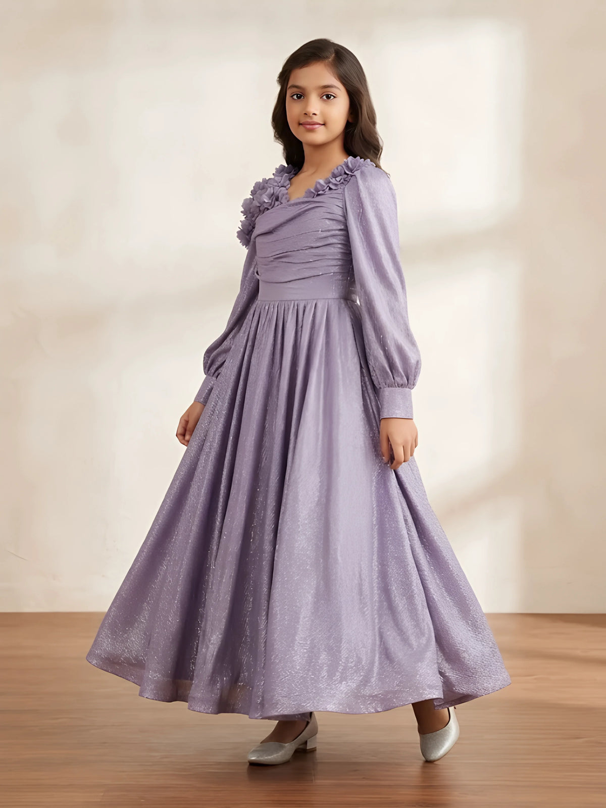 Purple metallic pleated gown for girls with ruffled shoulder details displayed on a white background.