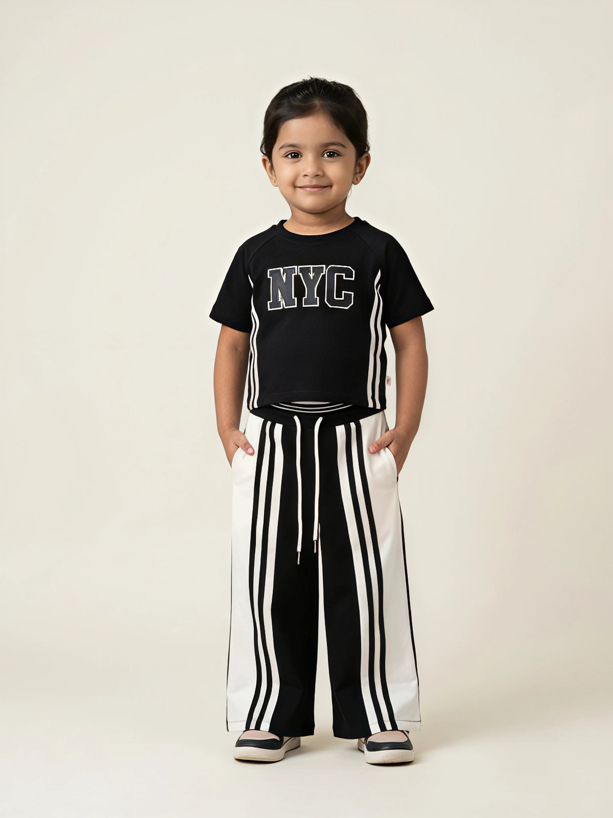 Black NYC letter print girls coordinate set featuring a short-sleeve top and matching striped pants.
