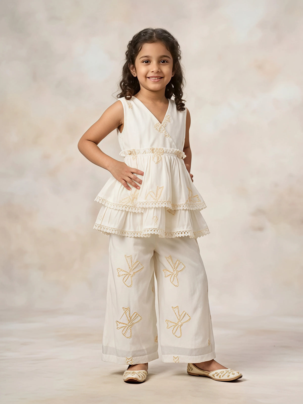 Girls wearing cream embroidered sleeveless peplum tunic and matching palazzo set