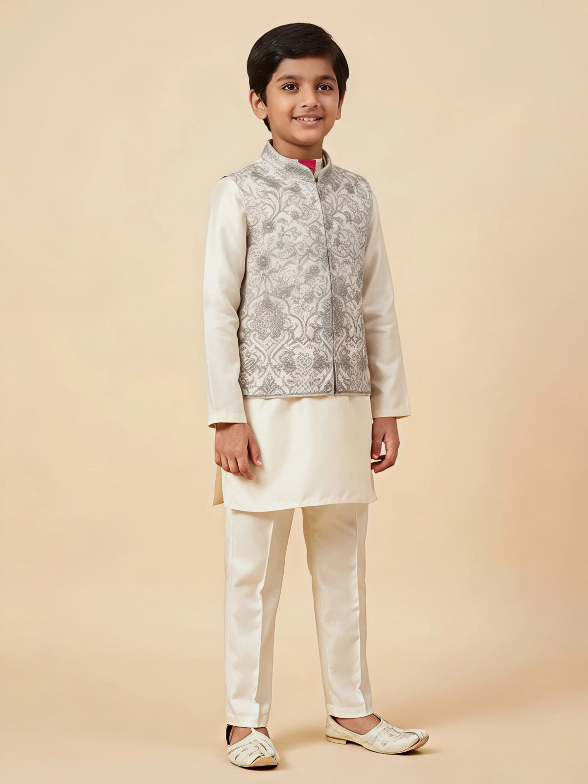 Cream embroidered kurta pajama set for boys with intricate floral patterns.