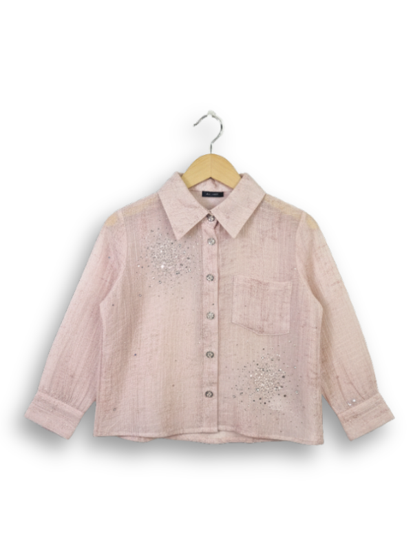 Front view of a girls' sheer peach long-sleeve button-up shirt with silver rhinestone clusters on the chest, hanging on a wooden hanger.