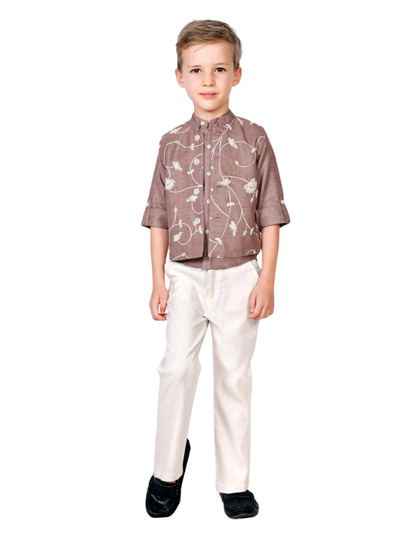 Young boy standing, wearing a short brown, collared kurta shirt with white floral embroidery and long, straight-cut cream/white trousers.
Export to Sheets
