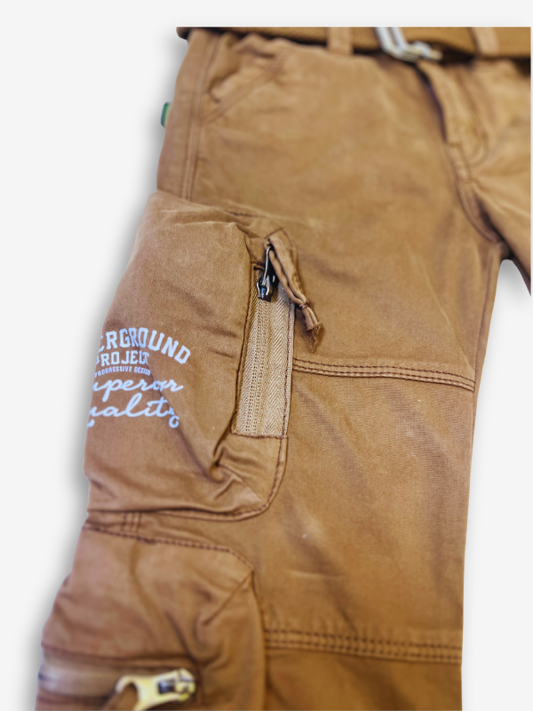 Boys' rustic brown cargo pants with many zippered side pockets, a matching web belt, and cuffed or slightly cropped leg openings.
Export to Sheets