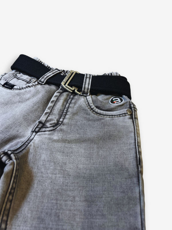 Boys' light grey wash denim jeans with a slightly faded look, an elasticated waist, and a thick black web belt with a silver rectangular buckle.