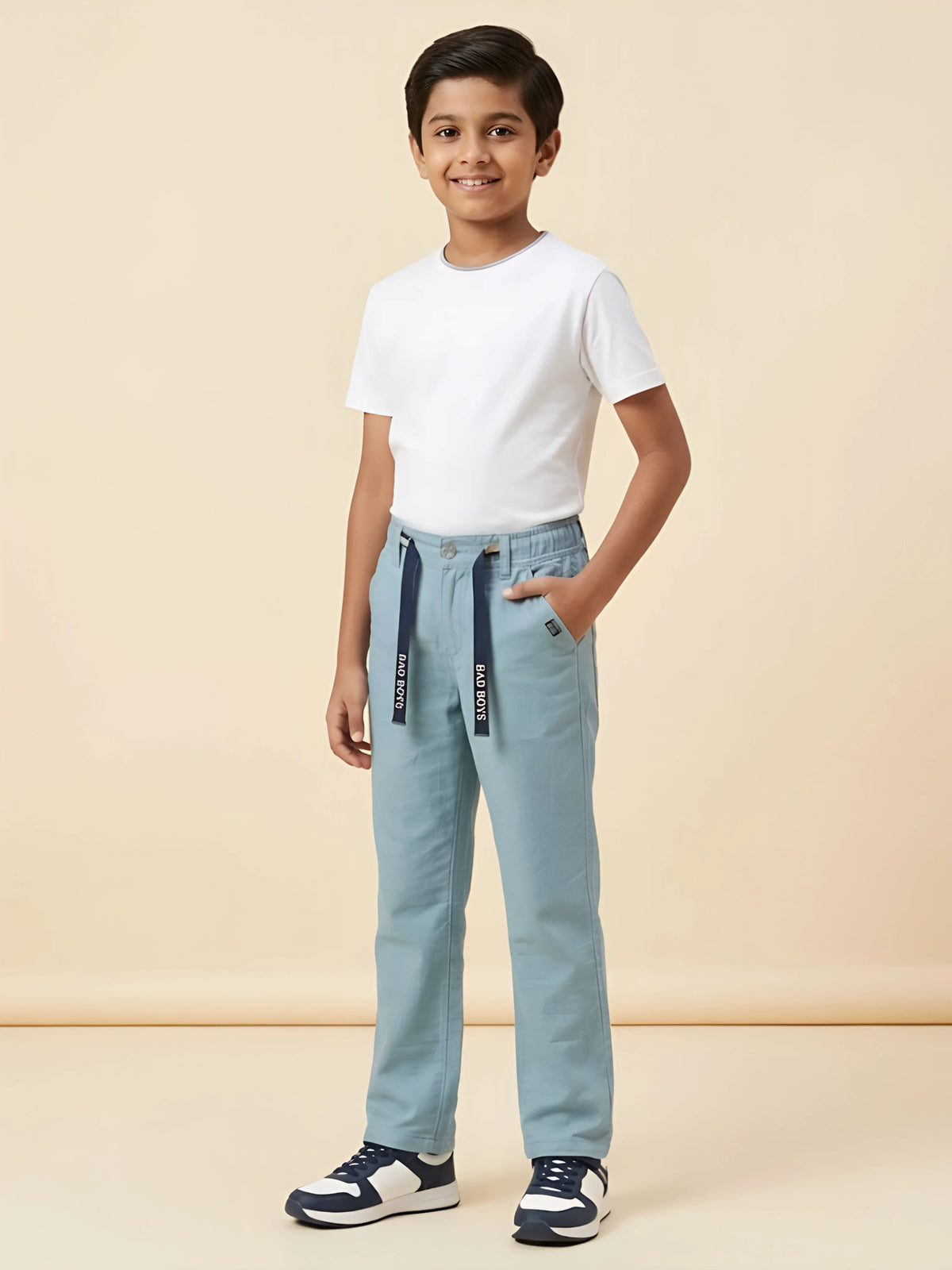 Young boy wearing light blue casual pants with a white t-shirt and dark blue drawstrings