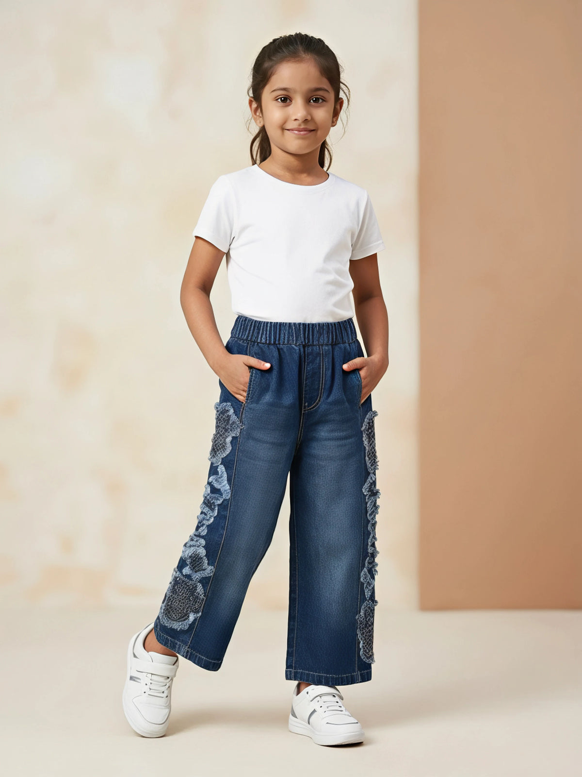 Young girl wearing Navy Blue Casual Pants with side lace detailing, elastic waistband, and side pockets paired with a white t-shirt and white sneakers.