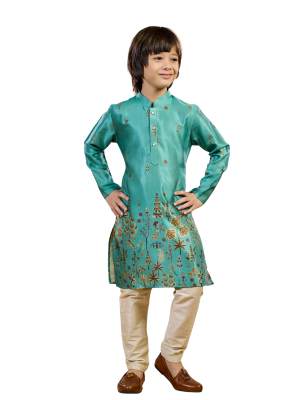 Full-length image of a young boy wearing a teal/sea-green traditional kurta with detailed gold botanical embroidery on the bottom hem, paired with gold/beige churidar pajamas and brown ethnic shoes.