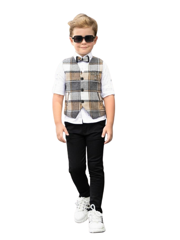 Young boy posing in a white long-sleeve shirt with sleeves rolled, a brown and cream plaid waistcoat, black trousers, a matching bow tie, and white sneakers.