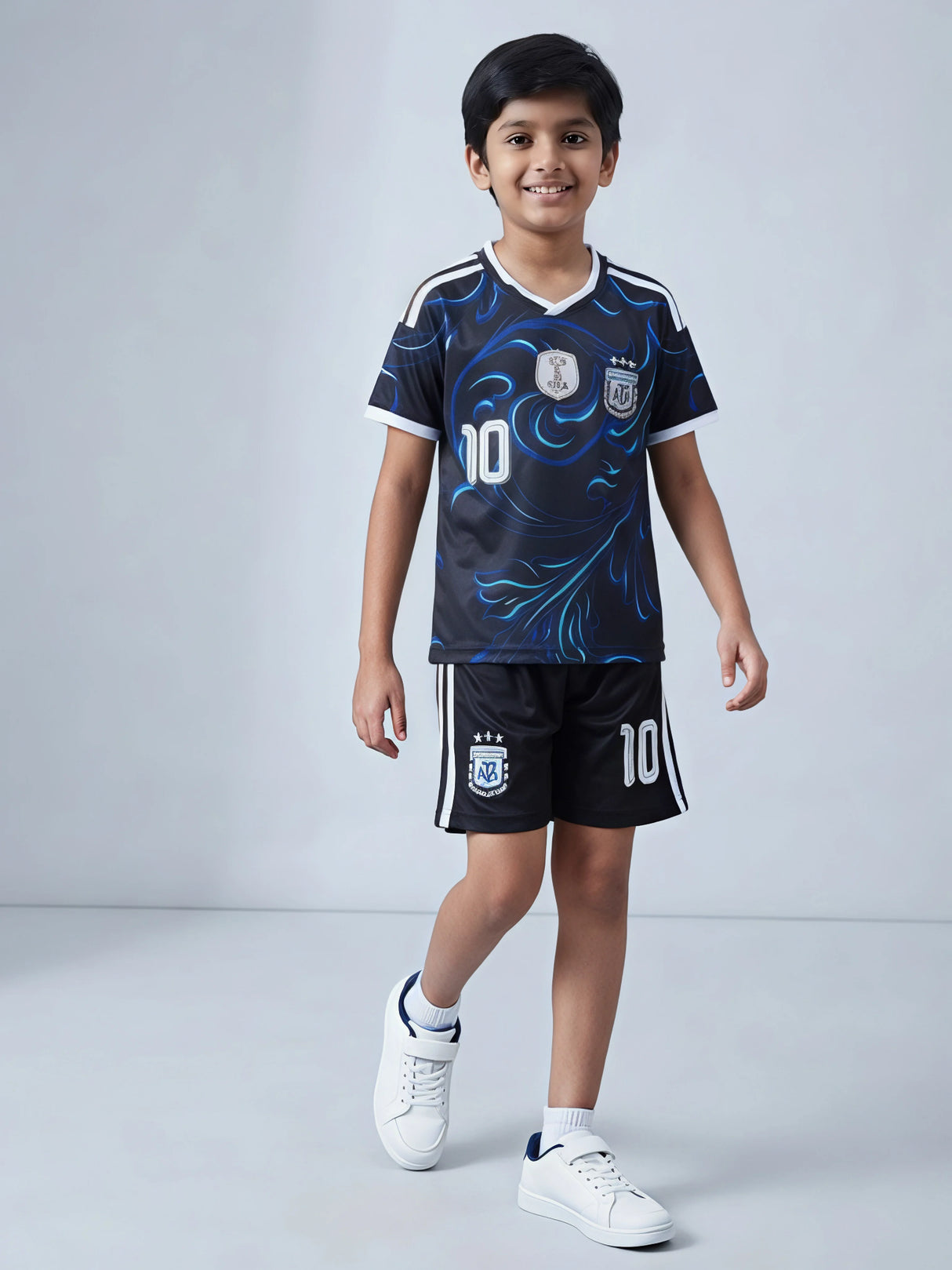 Young boy wearing a navy blue graphic football sports co-ord set with number 10 print and matching shorts