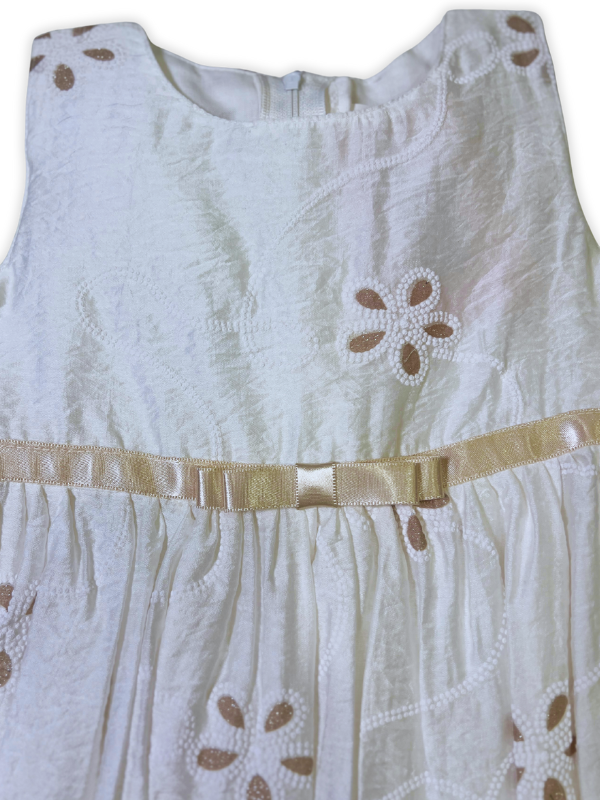 Cream girls' frock with spaghetti straps, a multi-colored crochet or patchwork upper bodice, and embroidered flowers on the skirt.
Export to Sheets