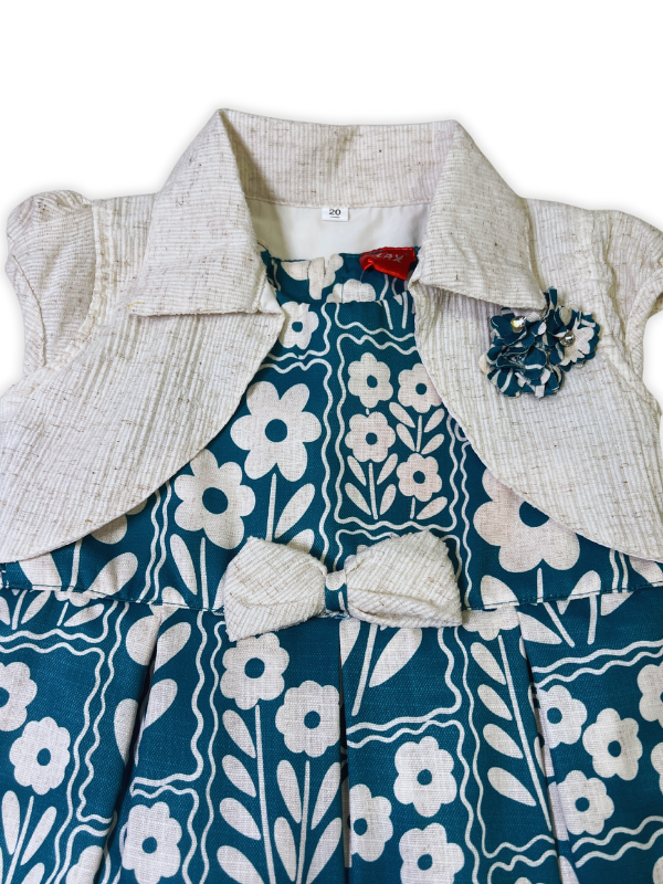 Girls' two-piece outfit featuring a teal and white oversized floral print dress with a detachable, cream-colored textured bolero jacket with a collar.
Export to Sheets