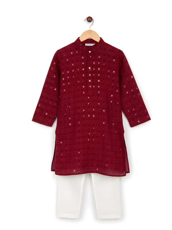 A boys' traditional outfit consisting of a long-sleeved, maroon kurta with all-over sequin embroidery and a Mandarin collar, paired with plain white pyjama pants.
