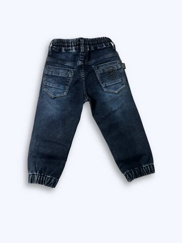 Close-up of boys' navy blue denim jogger pants with elastic waist, black drawstring, and elasticated ankle cuffs on a white background.