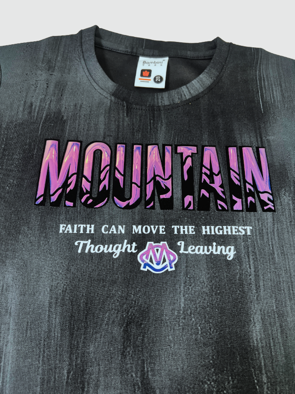 Black boys' short-sleeve T-shirt with a textured, blackout finish, featuring the word "MOUNTAIN" in a pink/purple gradient and a small motivational quote below