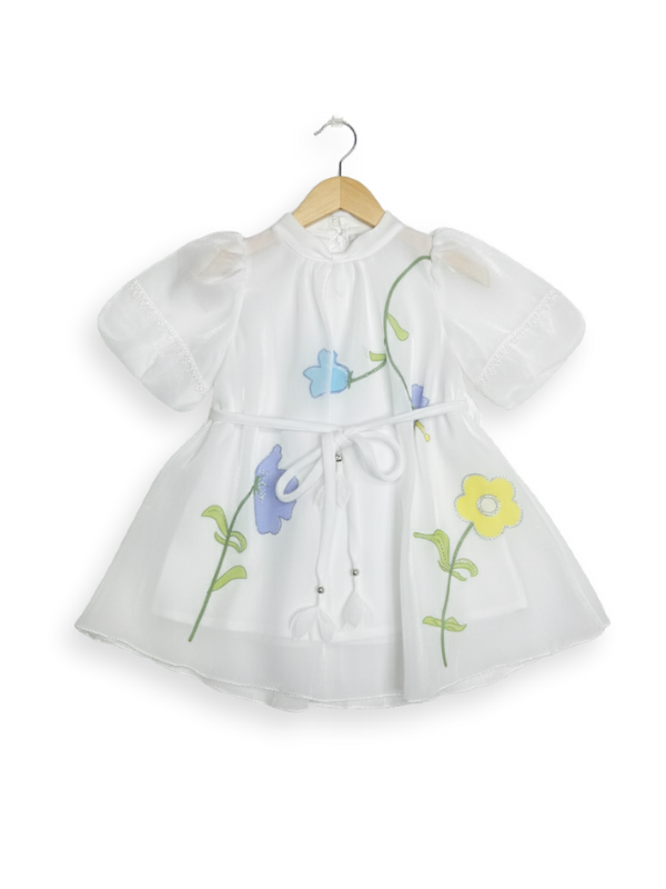 Front view of a girls' white sheer organza short-sleeve frock with painted/appliquéd blue, purple, and yellow floral designs and a matching white tie-belt with tassels.