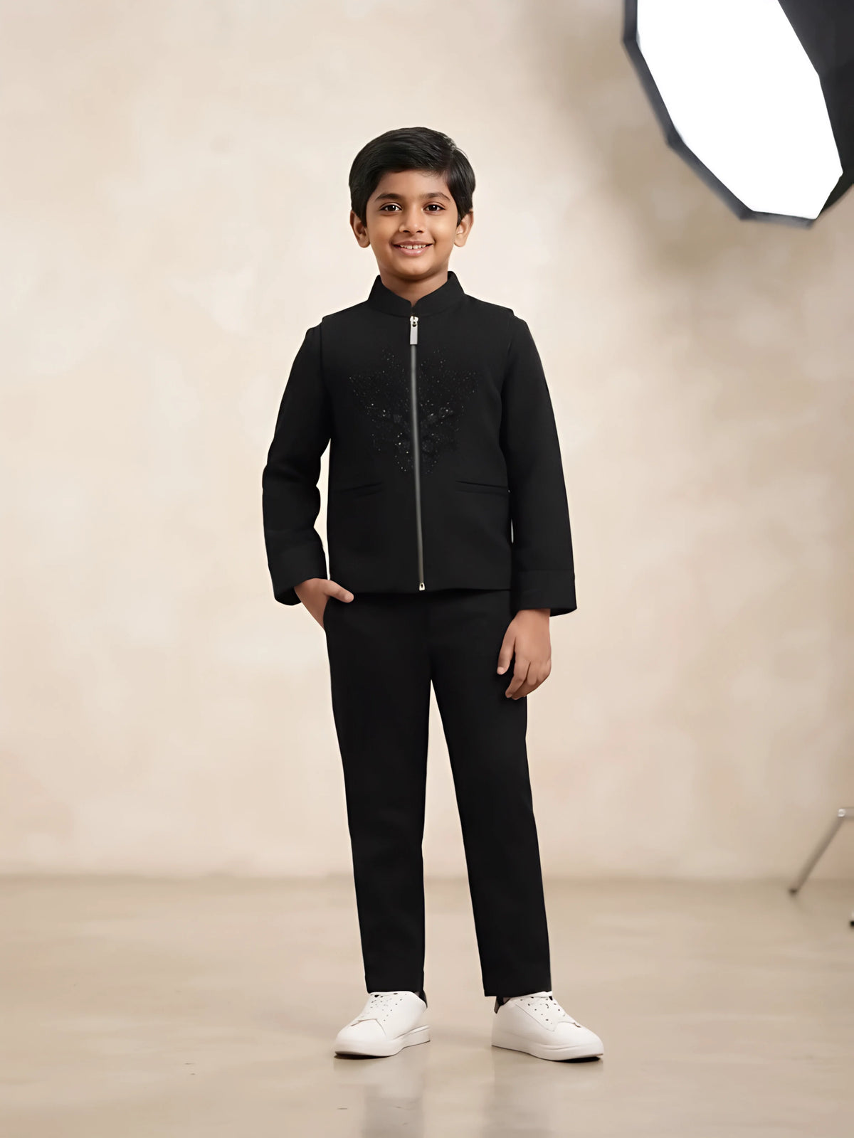 Boy wearing a sleek black embellished zip-front jacket with matching pants