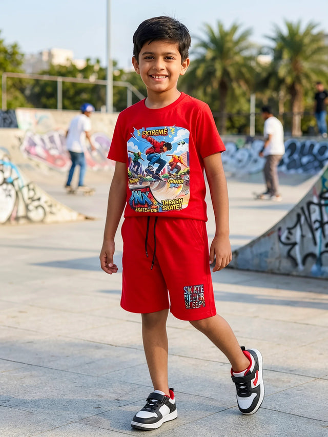 A young boy posing outdoors in a vibrant yellow co-ord set featuring a graphic print t-shirt and matching shorts with pockets, paired with white sneakers.