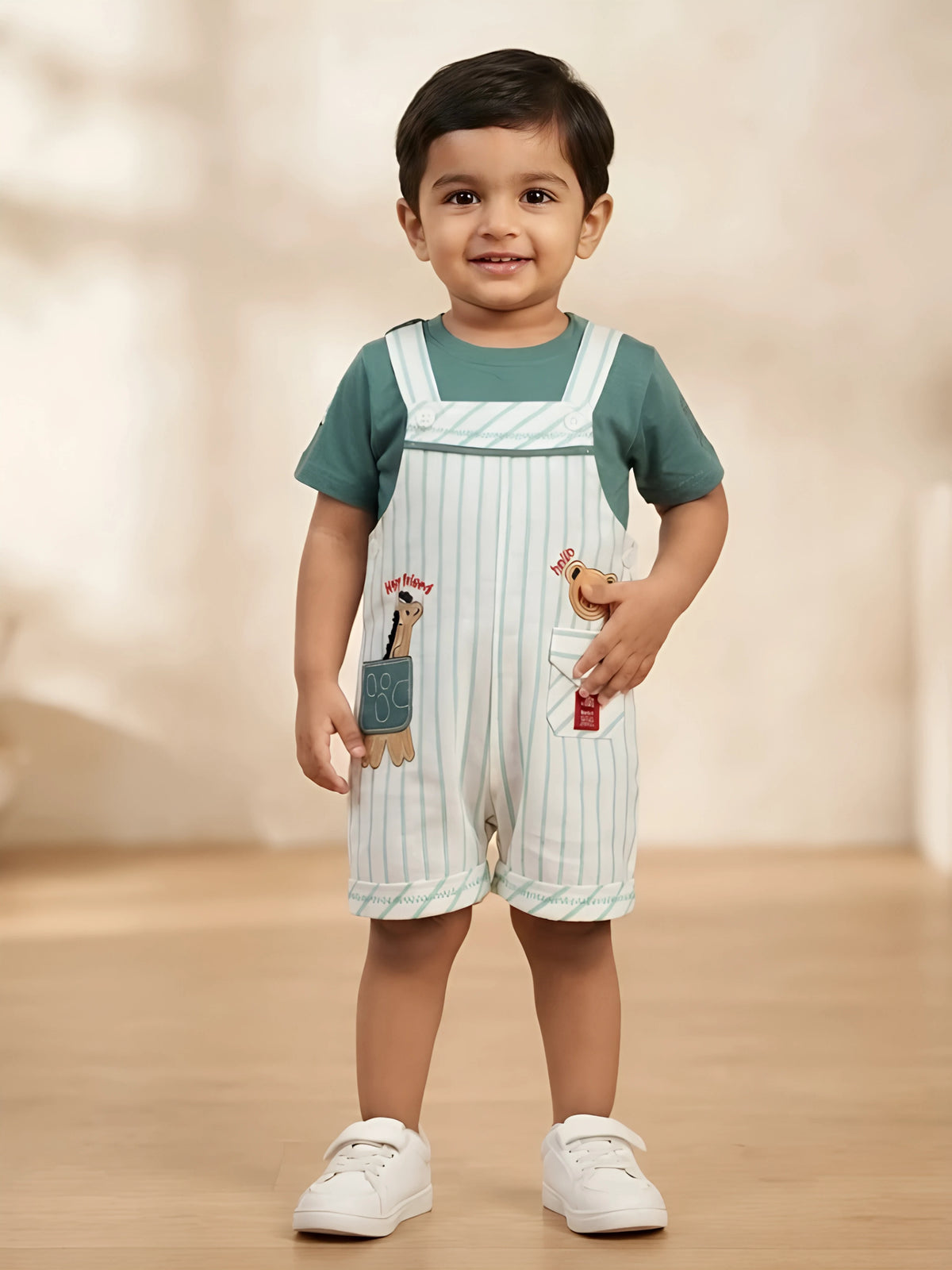 Infant boy wearing a green round-neck t-shirt and light green striped dungaree shorts with front pockets and animal patches.