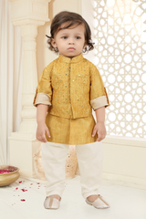  Young boy wearing a long-sleeved mustard yellow kurta with a small self-textured pattern, paired with white pajama trousers and gold ethnic shoes.