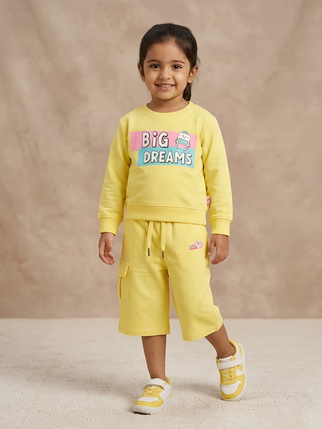 Yellow cotton girls coordinate set featuring graphic sweatshirt and matching shorts on a light background
