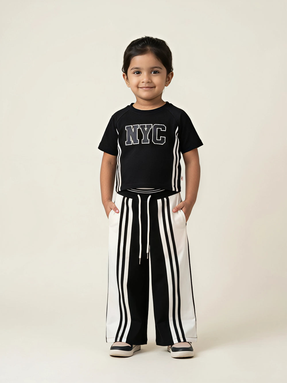 Black NYC letter print girls coordinate set featuring a short-sleeve top and matching striped pants.