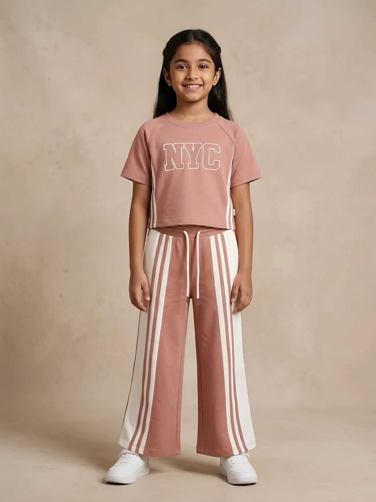 Young girl wearing a brown NYC graphic top and matching wide-leg striped trousers co-ord set