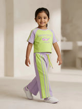 Purple and green graphic print girls coordinate set laid flat on a white background.