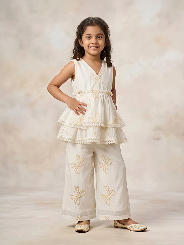 Girls wearing cream embroidered sleeveless peplum tunic and matching palazzo set