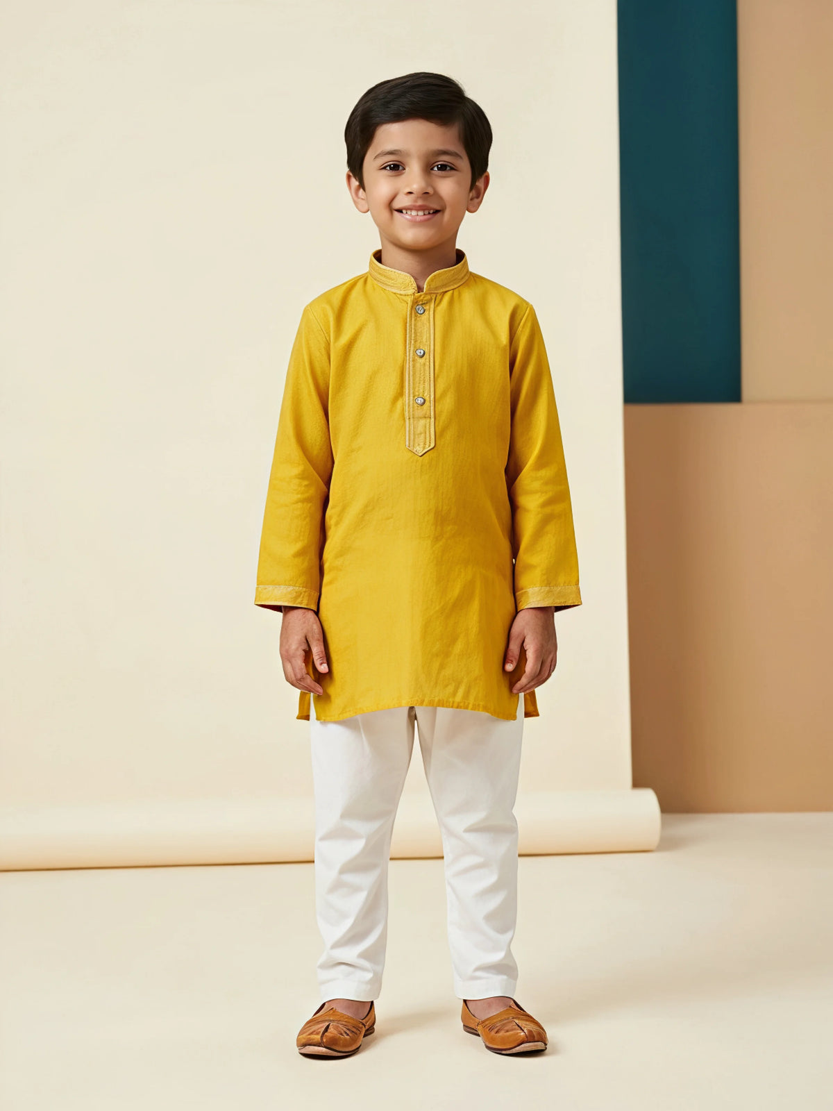 Young boy wearing a bright yellow mandarin collar kurta with white pyjamas