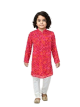 Young boy with curly hair wearing a long-sleeve bright red and pink Bandhani print kurta with a Mandarin collar, paired with solid white pyjama bottoms and traditional Indian shoes