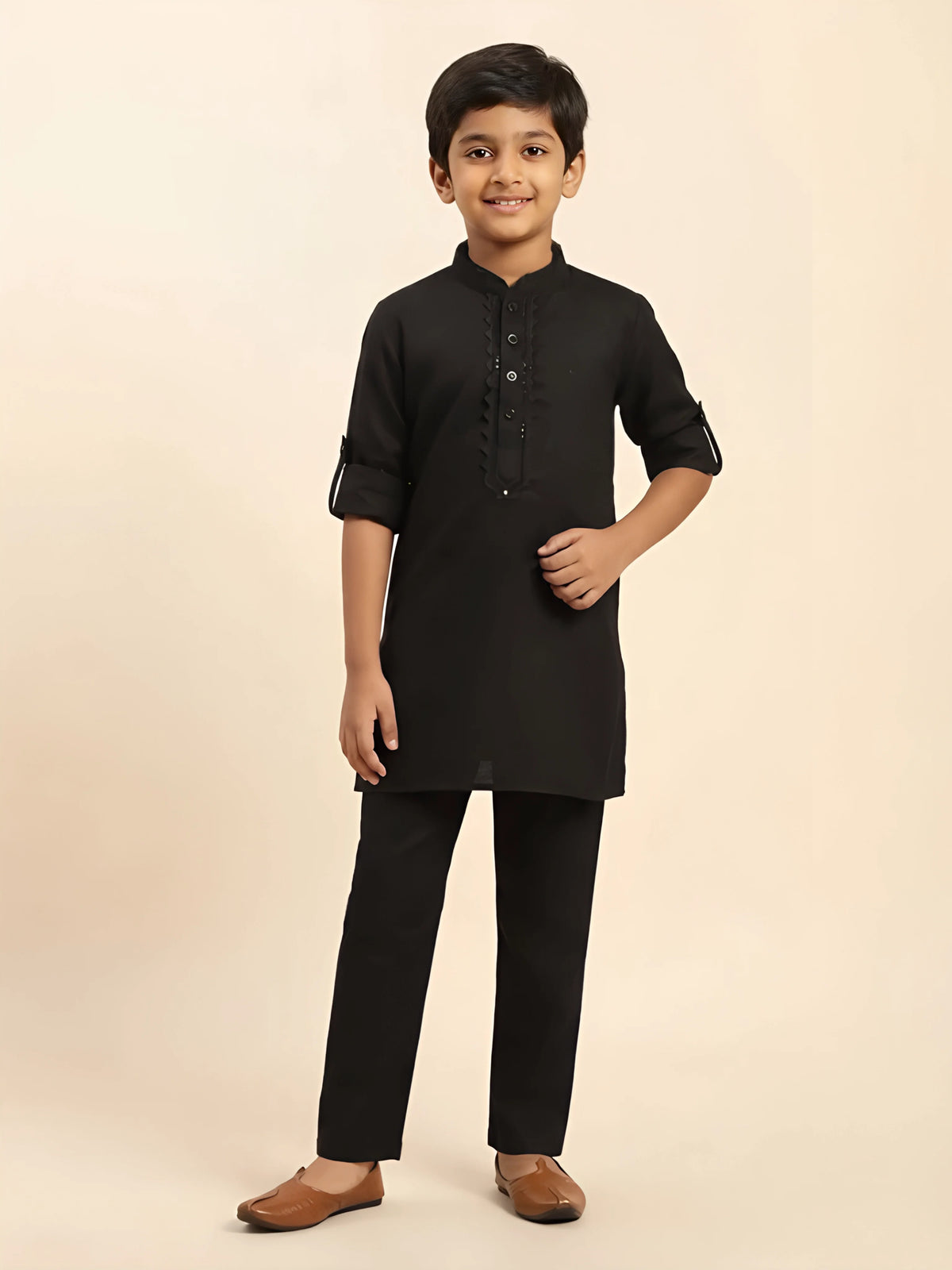 Folded black boys kurta pajama set with designer embroidered placket and matching pants.