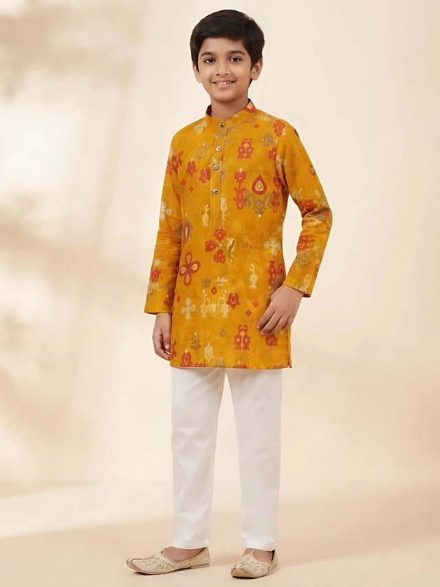 Yellow ikat print kurta pajama set for boys with white pajama pants.