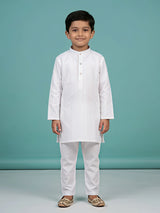 Young boy wearing a crisp white self-striped mandarin collar kurta with matching white trousers.