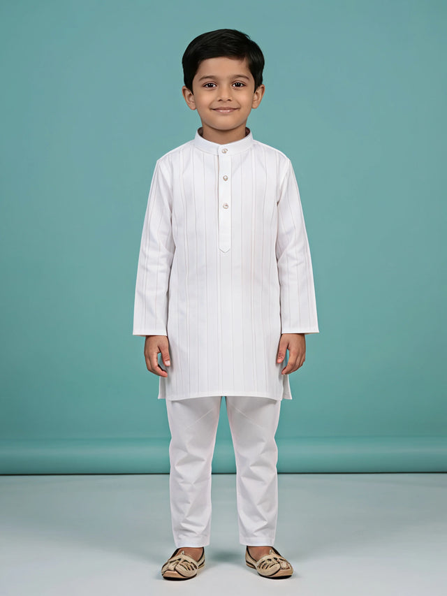 Young boy wearing a crisp white self-striped mandarin collar kurta with matching white trousers.