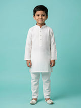 Young boy wearing a pristine white textured embroidery kurta set with mandarin collar and matching trousers