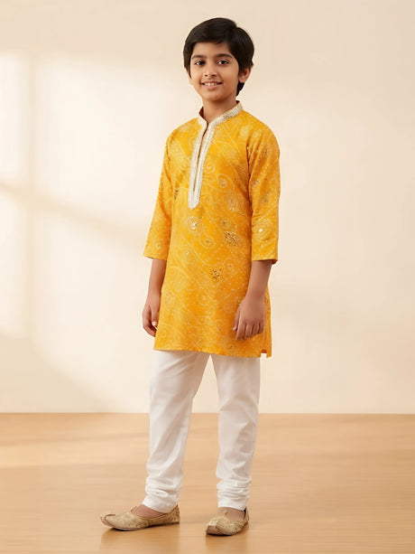 Yellow bandhani print kurta pajama set for boys with silver neck detailing.