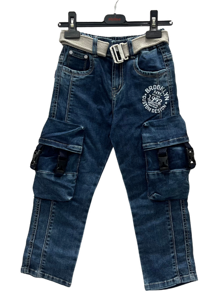 A pair of boys' dark wash denim cargo jeans hanging on a hanger, featuring large buckle-closure pockets on the legs, a white 'Brooklyn' graphic, and a light gray canvas belt.