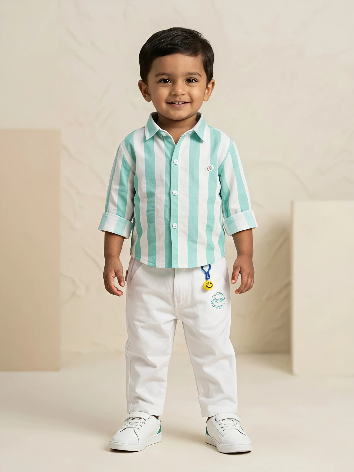 Young boy wearing a sea green and white vertical striped shirt with white trousers co-ord set