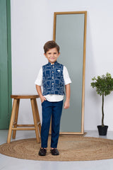 Young boy smiling in a blue Bandhani print ethnic waistcoat, white short-sleeve shirt, and matching blue tailored trousers. Full-length product shot for a boy's festive suit set.