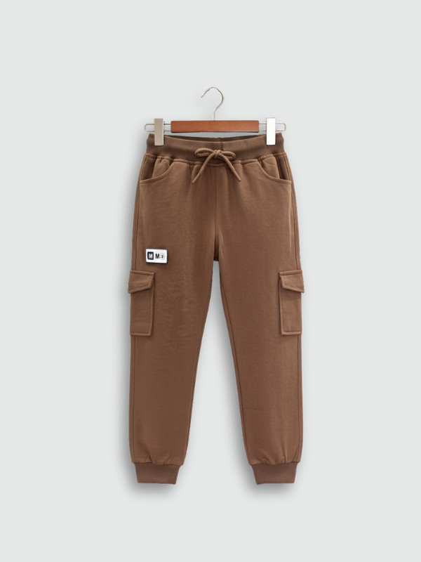 Boys' plain brown fleece cargo jogger pants with elastic drawstring waist and cuffed ankles, hanging on a wooden hanger.