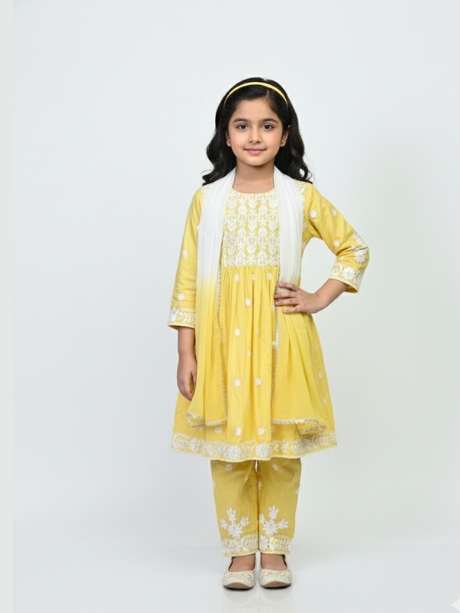 Full-length image of a young girl wearing a bright yellow, white-embroidered, flared frock (kurta) with matching yellow pants and a white dupatta.