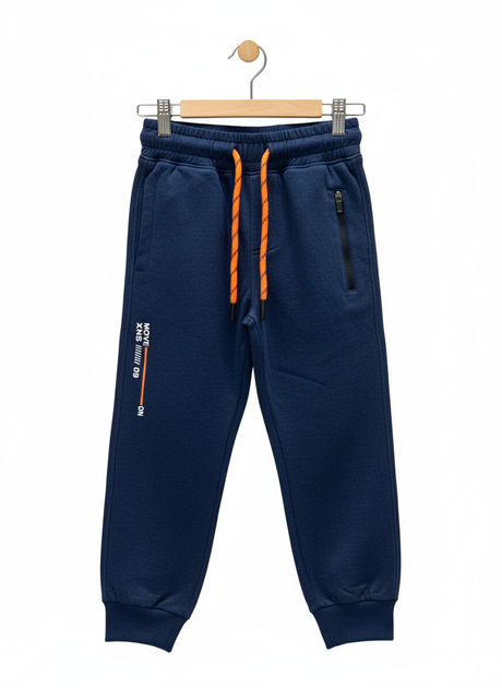 A pair of boys' navy blue fleece jogger track pants with an elastic waist, orange and black contrast drawstring, ribbed ankle cuffs, and a vertical zippered pocket.