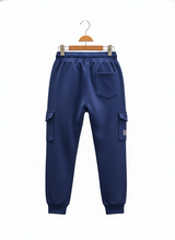 Back view of boys' navy blue fleece jogger track pants, showing cargo pockets, one back pocket, and ribbed cuffs.