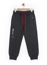 A pair of boys' dark grey fleece jogger track pants with an elastic waist, red and black contrast drawstring, ribbed ankle cuffs, and a vertical zippered pocket.