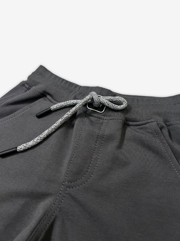 Boys' dark charcoal grey jogger pants with an elastic waist, cuffed ankles, and a visible speckled grey and white rope drawcord.

Export to Sheets