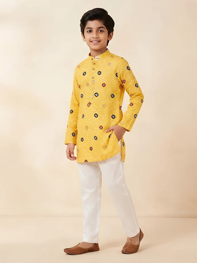 Yellow bandhani print kurta with white pajama set for boys.