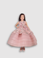 Young girl modeling a voluminous, sleeveless dusty pink party frock with a tiered skirt, a sparkling bodice, and a large bow detail on the waist.