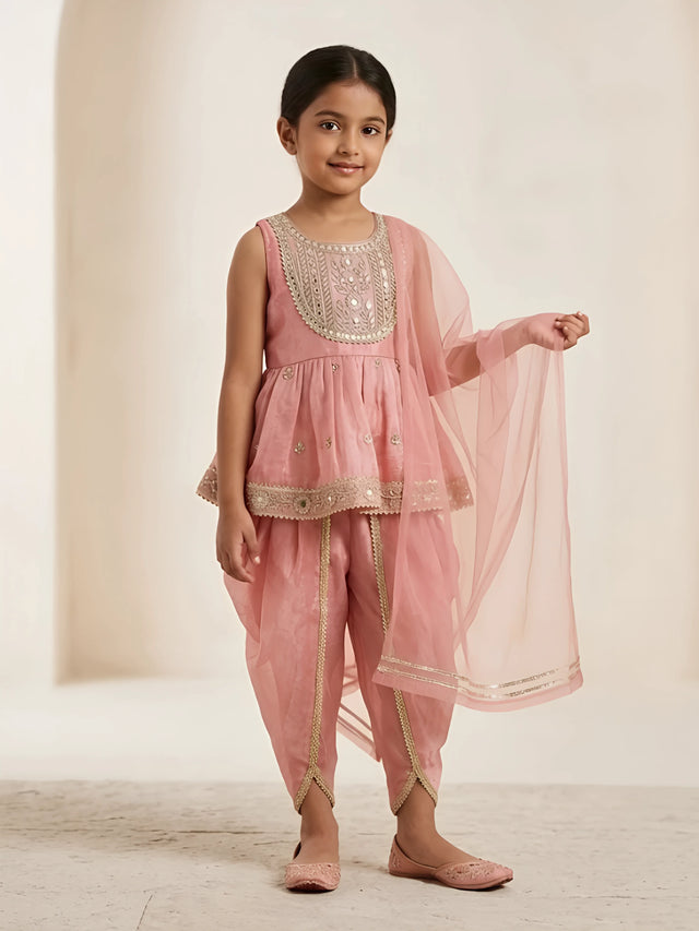 Girls peach sleeveless embroidered peplum tunic paired with matching dhoti pants and net dupatta.