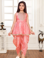 Young girl modeling a sleeveless peach/pink ethnic wear set with a short, flared peplum Kurti top and draped dhoti-style pants.