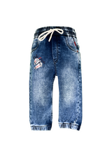 Boys' medium blue wash jogger pants with an elastic waist, white drawstring, embroidered patch on the left thigh, and cuffed ankles.

Export to Sheets